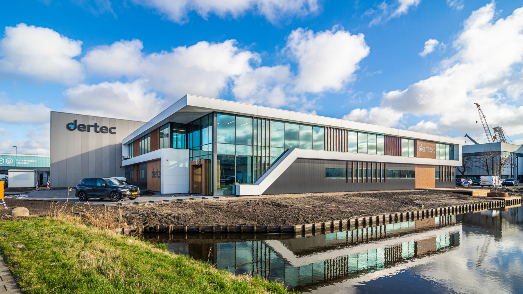 Modern bedrijfspand dertec aan het water onder een wolkenlucht