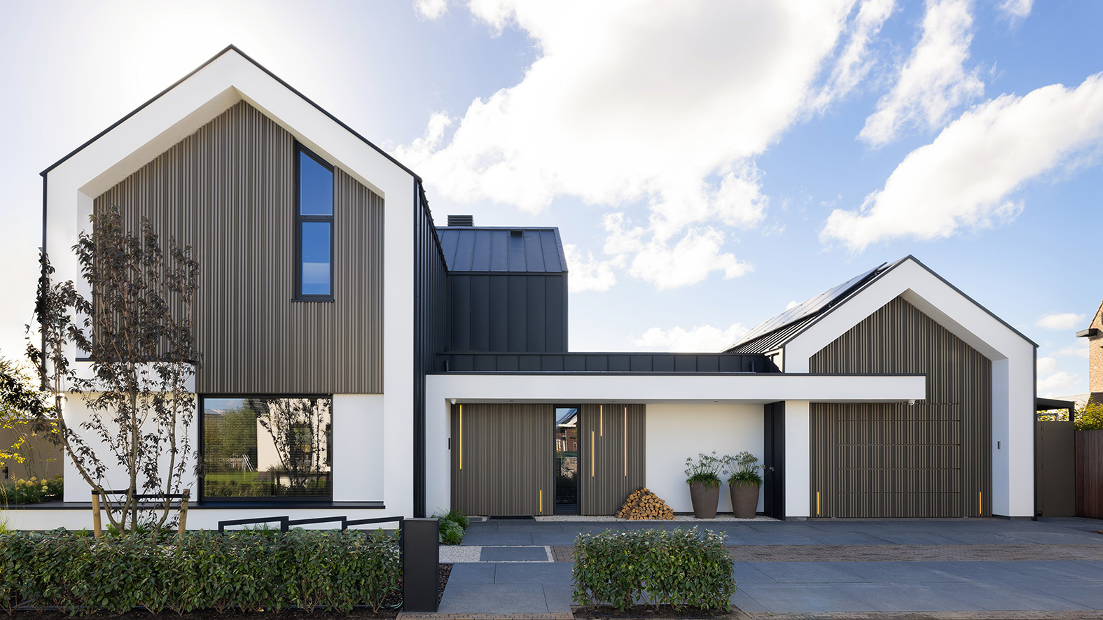 Moderne villa met verticale houten gevel en witte puntgevels